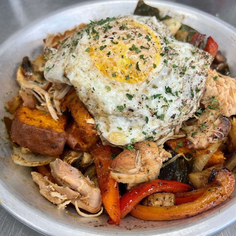 A Farm Fresh Fast bowl with chicken, sweet potatoes, peppers, and a fried egg.